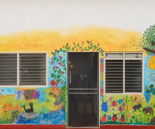 Mural artístico comunitario realizado por familias de Escuela Libre