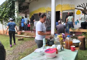 Mesa con compartir de alimentos y bebidas naturales durante la actividad comunitaria en Escuela Libre.